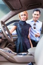 Asian couple choosing luxury car in dealership