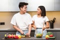 Asian Couple Cooking Together Preparing Salad For Dinner In Kitchen Royalty Free Stock Photo