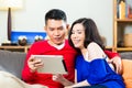 Asian couple on the couch with a tablet pc