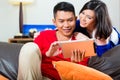 Asian couple on the couch with a tablet pc