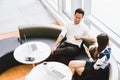 Asian couple or coworkers having coffee break while working on laptop computer at cafe, coffee shop or modern office Royalty Free Stock Photo