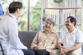 Asian couple Elderly men and women sit on sofas having fun and having fun talking with doctors who come to check their health at Royalty Free Stock Photo