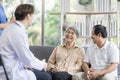 Asian couple Elderly men and women sit on sofas having fun and having fun talking with doctors who come to check their health at Royalty Free Stock Photo