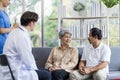 Asian couple Elderly men and women sit on sofas having fun and having fun talking with doctors who come to check their health at Royalty Free Stock Photo