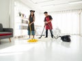Asian couple family cleaning bedroom with yellow twist mob and vacuum cleaner on the floor in the weekend Royalty Free Stock Photo