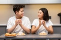 Asian Couple Having Breakfast Sitting In Kitchen On Weekend Morning Royalty Free Stock Photo