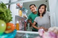 asian couple hold their belly while open the fridge door looking for something to eat Royalty Free Stock Photo