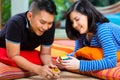 Asian couple at home playing with magic cube