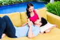 Asian couple huddling on sofa in living room of home