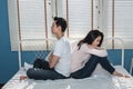 Asian couple, husband and attractive wife, sit back and forth in white bed