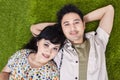 Asian couple laying on green grass Royalty Free Stock Photo