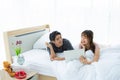 A couple using laptop with happy on the bed