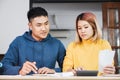 Asian couple list home financial bill budget on table in kitchen