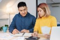 Asian couple list home financial bill budget on table in kitchen at new house.family expense