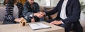 Asian couple looking at house plans and talking with a real estate agent about signing documents for purchase of a new Royalty Free Stock Photo