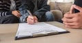 Asian couple looking at house plans and talking with a real estate agent about signing documents for purchase of a new Royalty Free Stock Photo