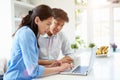 Asian Couple Looking at Laptop In Kitchen