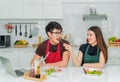 Asian couple in love is sitting in kitchan by woman is feeding sausage her man Royalty Free Stock Photo