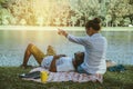 Asian couple lover sitting a relax River side in the public park. working with a notebook and drinking coffee.in the park. in the