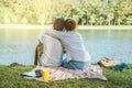 Asian couple lover sitting a relax River side in the public park. working with a notebook and drinking coffee.in the park. in the