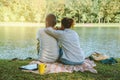 Asian couple lover sitting a relax River side in the public park. working with a notebook and drinking coffee.in the park. in the