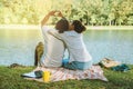 Asian couple lover sitting a relax River side in the public park. working with a notebook and drinking coffee.in the park. in the