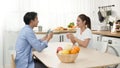 Asian couple newlyweds drink espresso and hot latte in a mug for brunch with nutrition fruit in a wooden bowl when talking about