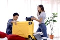 Asian couple packing clothes into suitcase. Preparing for honeymoon trip. Happy asian couple packing suitcase on the bed in room. Royalty Free Stock Photo