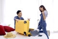 Asian couple packing clothes into suitcase. Preparing for honeymoon trip. Happy asian couple packing suitcase on the bed in room. Royalty Free Stock Photo