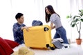 Asian couple packing clothes into luggage. Preparing for honeymoon trip. Happy asian couple packing suitcase on the bed in room. Royalty Free Stock Photo