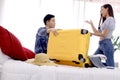 Asian couple packing clothes into luggage. Preparing for honeymoon trip. Happy asian couple packing suitcase on the bed in room. Royalty Free Stock Photo