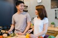 Asian couple prepare food together. Beautiful happy asian man and woman are cooking in the kitchen. Royalty Free Stock Photo