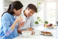 Asian Couple Reading Newspaper At Breakfast Royalty Free Stock Photo