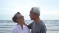 Asian couple senior elder retire resting relax kissing and hugging sunset beach