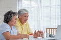 Asian couple seniors use laptop video conference with doctor about illness and prescription pill in living room at home.Healthy