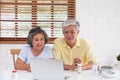 Asian couple seniors use laptop video conference with doctor about illness and prescription pill in living room at home.Healthy