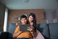 Asian Couple shopping online and paying with credit card at laptop computer,Happy couple at home surfing the net on sofa Royalty Free Stock Photo