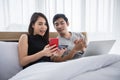 Asian Couple shopping online and paying with credit card on laptop and mobile phone at home,Happy couple at home surfing the net Royalty Free Stock Photo