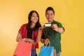 asian couple showing the blank card while holding the shopping bags Royalty Free Stock Photo