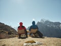 Asian couple sitting in chair on top of mountain looking at view Royalty Free Stock Photo