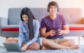 Asian couple sitting and relaxation by technology in living room at home Royalty Free Stock Photo