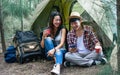 An asian couple sitting together and talking in the morning while taking rest and camping in forest in summer holiday or vacation Royalty Free Stock Photo