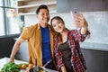 asian couple taking selfie while cooking together in the kitchen Royalty Free Stock Photo