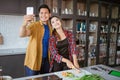 asian couple taking selfie while cooking together in the kitchen Royalty Free Stock Photo