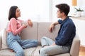 Asian Couple Talking Enjoying Conversation Sitting On Couch At Home Royalty Free Stock Photo