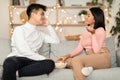 Asian Couple Talking Enjoying Stay-At-Home Date Sitting On Sofa Indoors Royalty Free Stock Photo