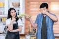 Asian couple Are teasing each other in the kitchen, where the wife was pointing at the eggplant