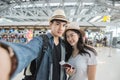 Asian couple tourist taking a selfie in airport before journey