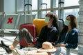 Asian couple of tourists in waiting area of airport terminal sit and nap before departure and check-in Royalty Free Stock Photo