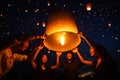 Asian couple traveller setting yi peng lantern in loi krathong festivities